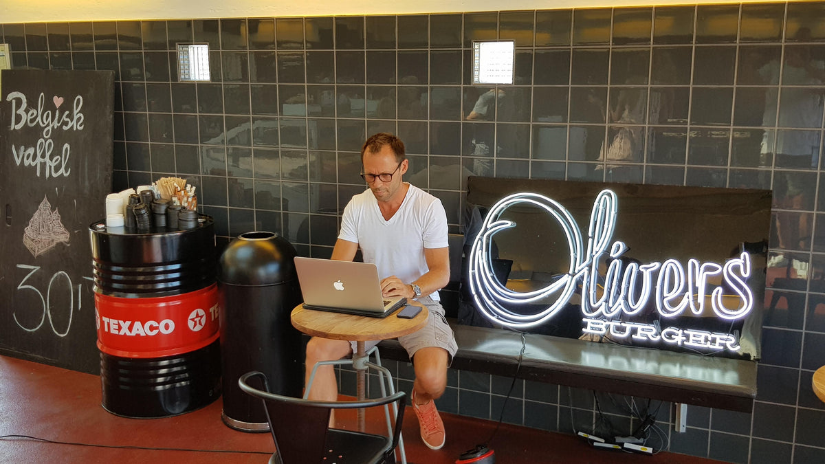 Hvidt neonlogo for Olivers Burger i en restaurant