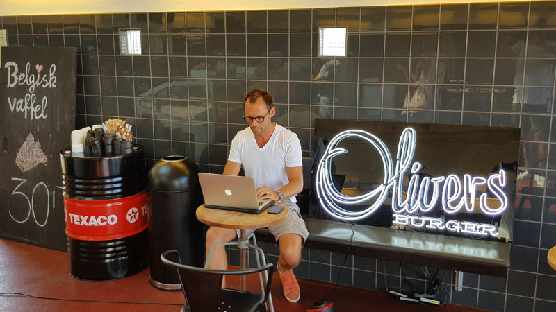 Hvidt neonlogo for Olivers Burger i en restaurant