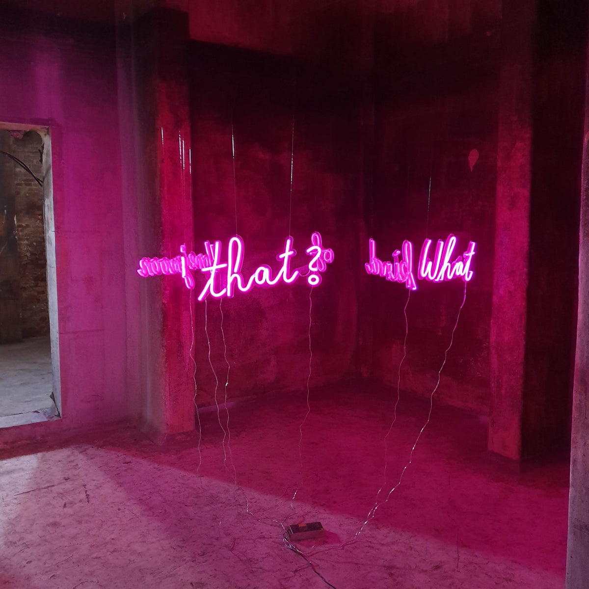 Pink neontekst ophængt i et forladt rum