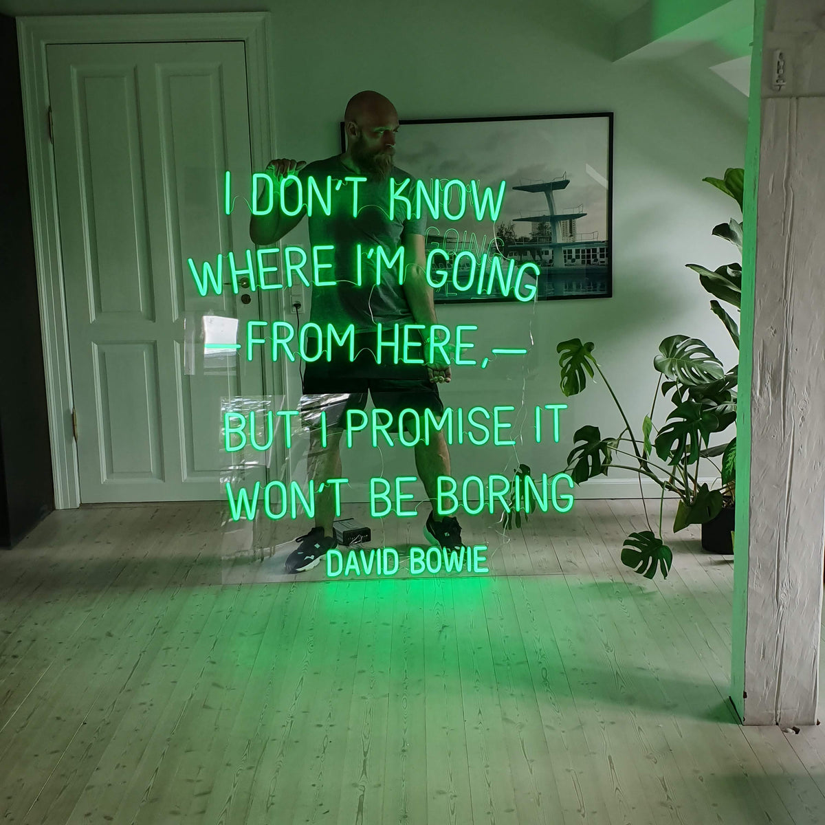 Grønt neoncitat af David Bowie på en klar plade