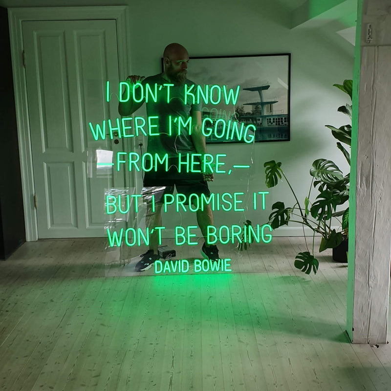 Grønt neoncitat af David Bowie på en klar plade