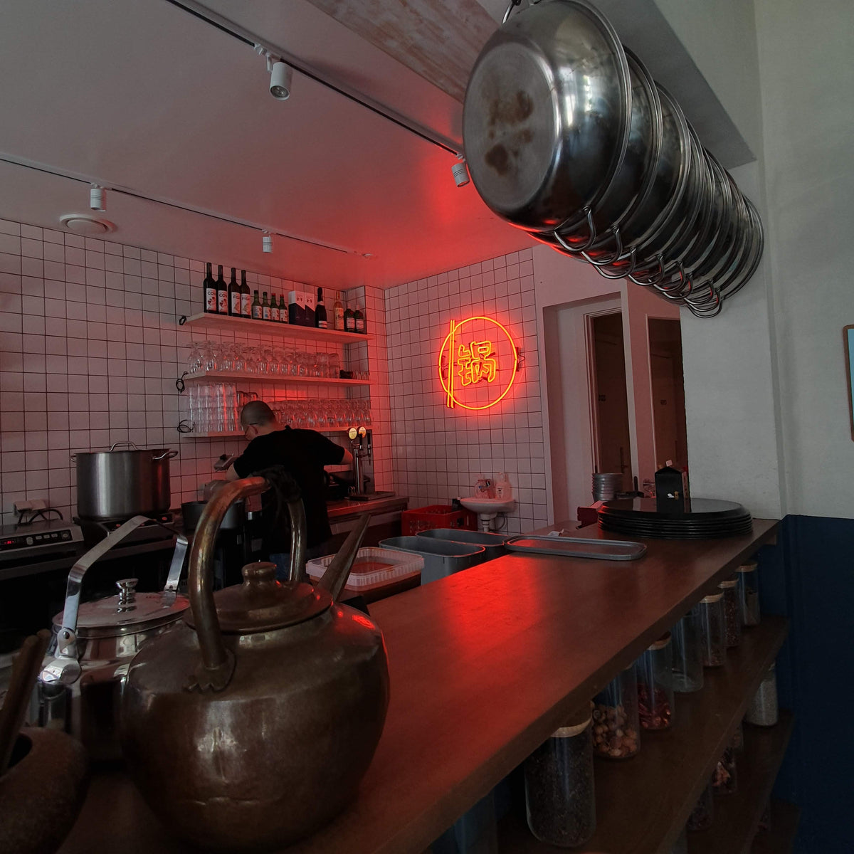 Rødt neonskilt med kinesisk tegn over baren i en hotpot-restaurant
