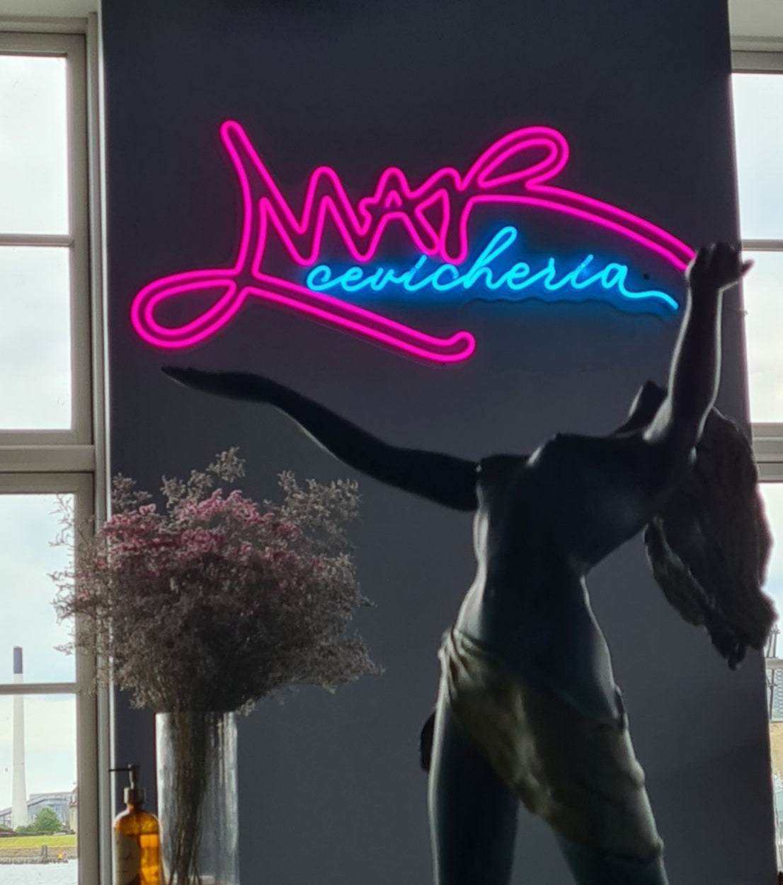 Pink og blåt neonlogo for Mar Cevicheria på en mørk væg