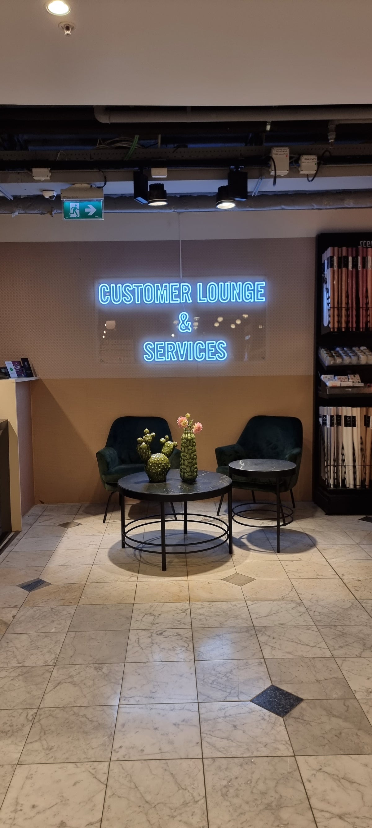 Blåt neonskilt med CUSTOMER LOUNGE &amp; SERVICES i en butik