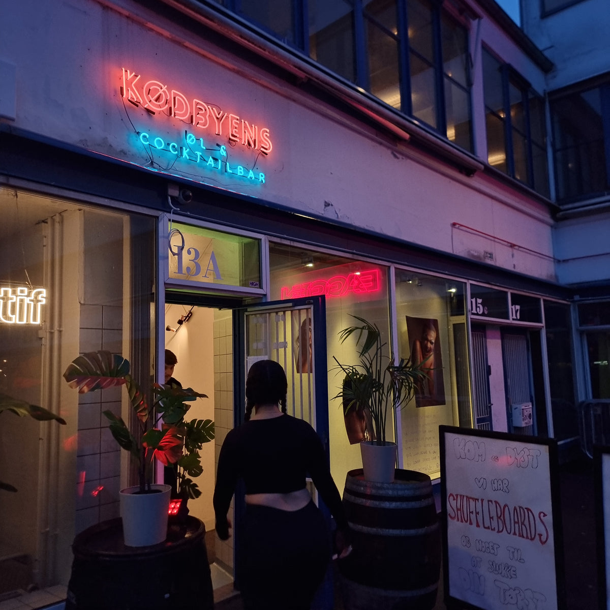 Neonskilt i rød og blå over indgangen til Kødbyens Øl &amp; Cocktailbar