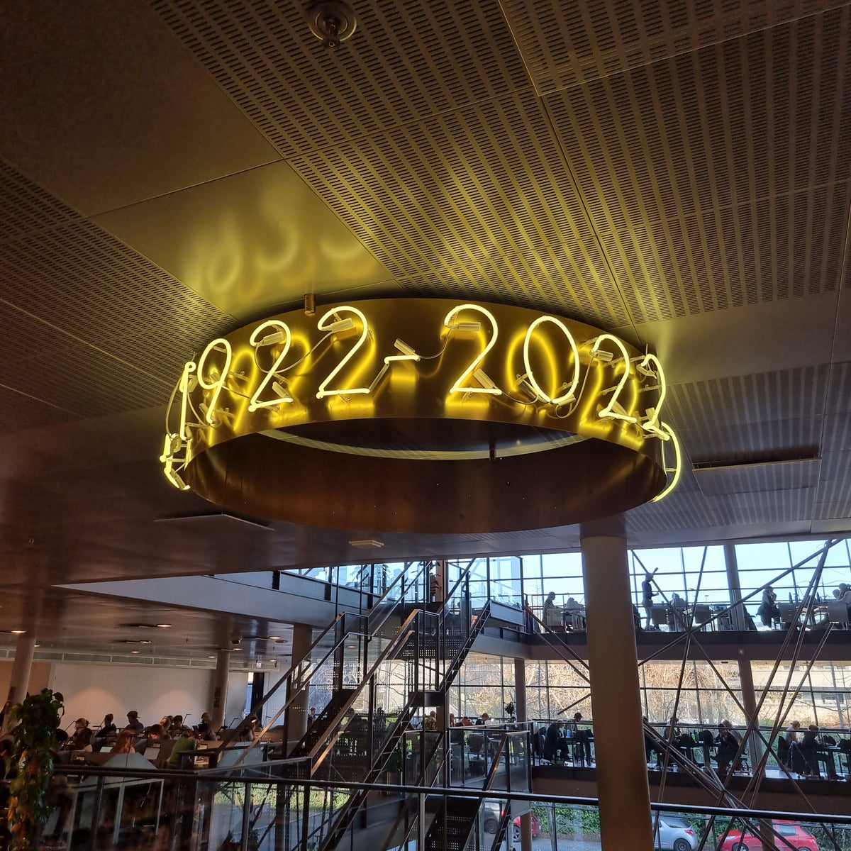 Gul neonring med 1922-2022 til et jubilæum i et atrium