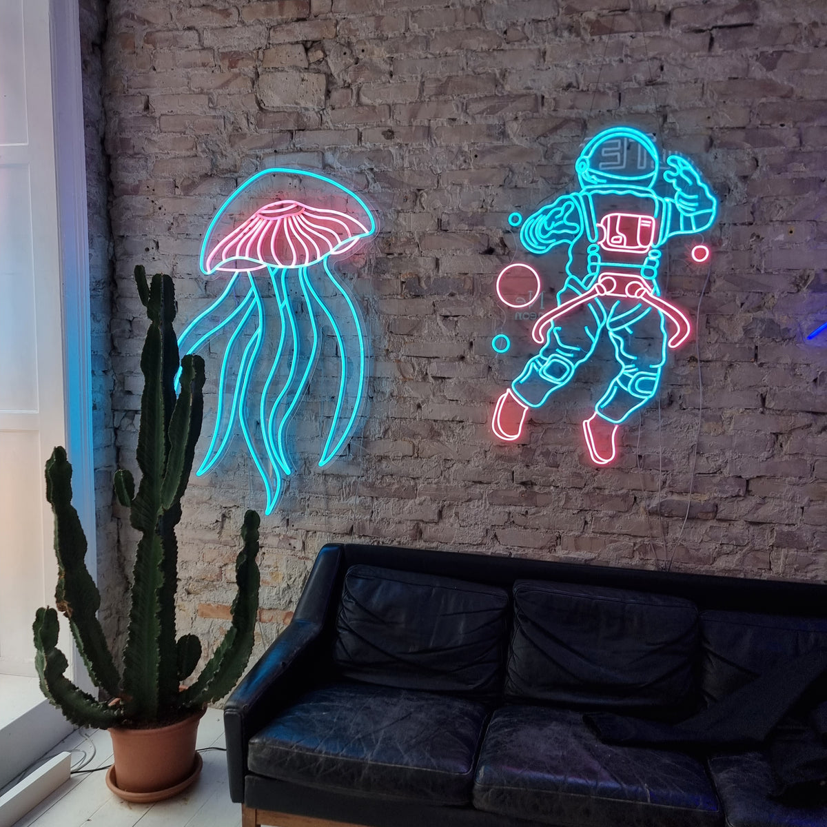 Neonvandmand og neonastronaut på en murstensvæg over en sofa