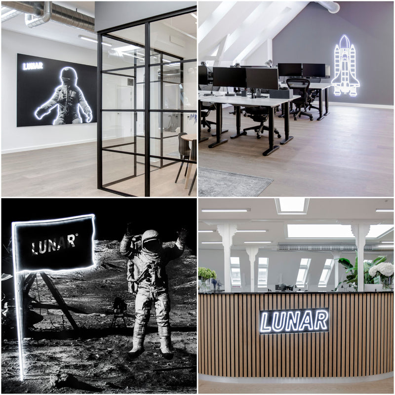 Hvide LED-neonskilte med LUNAR-logoet i en reception og på kontorvægge