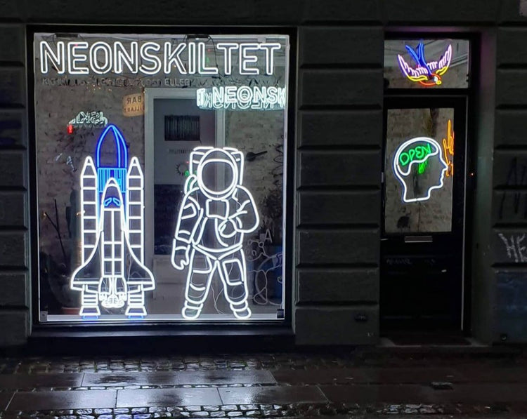 Neonskiltets butiksvindue med en rumraket og en astronaut i lysende LED-neon
